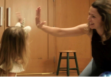 Woman high-fiving child during reading lesson