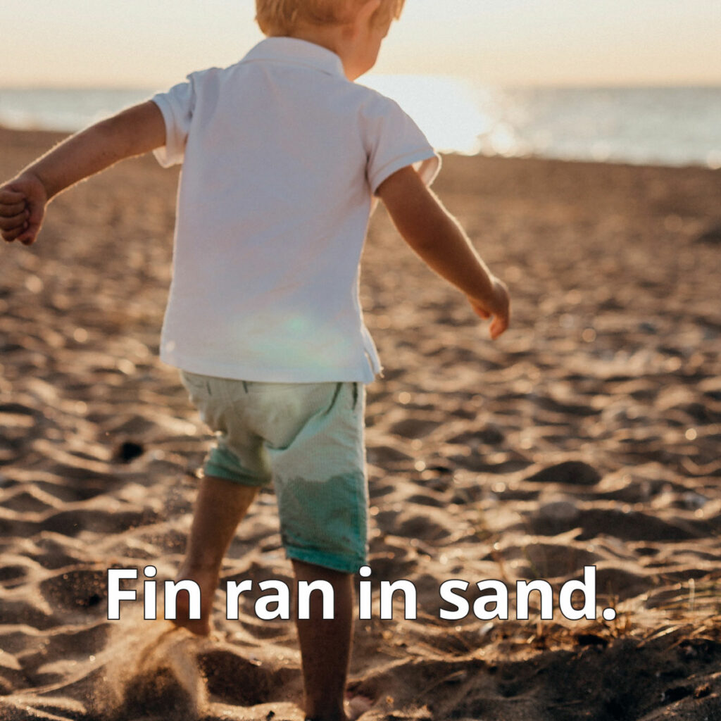Sand reader image of child jumping in sand on beach